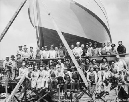 Group portrait of boat builders posing in front of tuna boat Sea Wolf