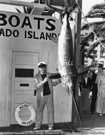 Man posing with swordfish caught from sportfishing boat Aztec IV