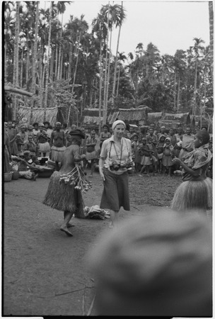 Mortuary ceremony, Omarakana: anthropologist Annette Weiner at exchange ritual, another woman puts betel nut clusters on e...