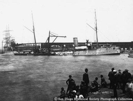 View of San Diego harbor showing people on dock and ships in background
