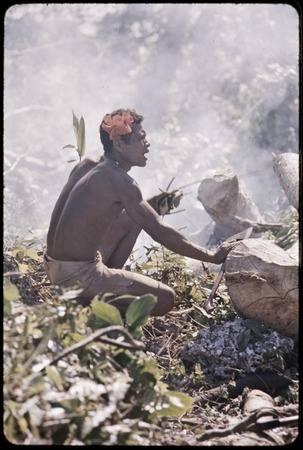 Land clearing: man with an axe, next to a large tree that has been cut down