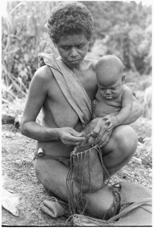 Fulabata (Batalamo&#39;s wife) and child, getting tobacco from bag.
