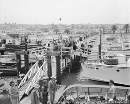 General view of fishing boats docked at pier and sportfishermen