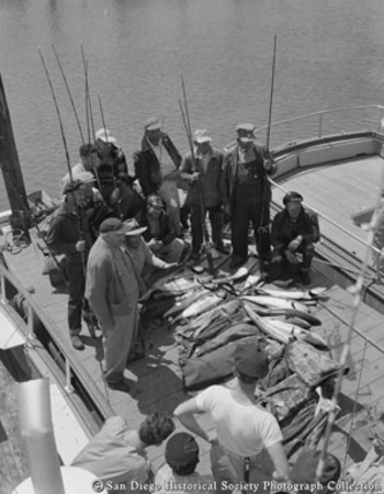 Group of fishermen on sportfishing boat posing with catch