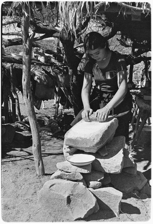 Grinding rock salt on a metate for cheese production at Rancho El Cerro