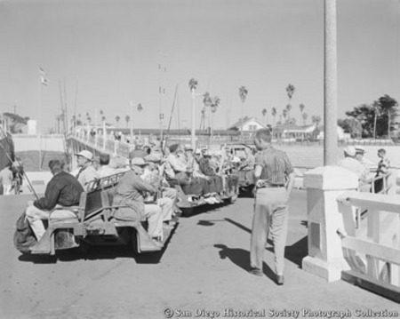 Men with fishing rods sitting on benches at Oceanside