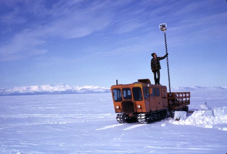 Arthur DeVries with ice augur for checking thickness of sea ice for safe driving, on Pole Cat. near McMurdo Station, Antar...