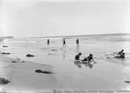 Children playing in ocean surf on beach at Cardiff by the Sea