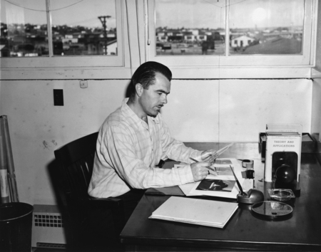 Man examining photographs, University of California Division of War Research