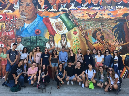 group picture of Communication 190 class in front of mural at Chicano Park