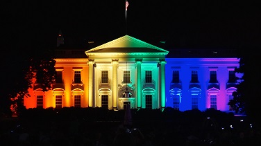 the US White House light up from the outside with different color lights