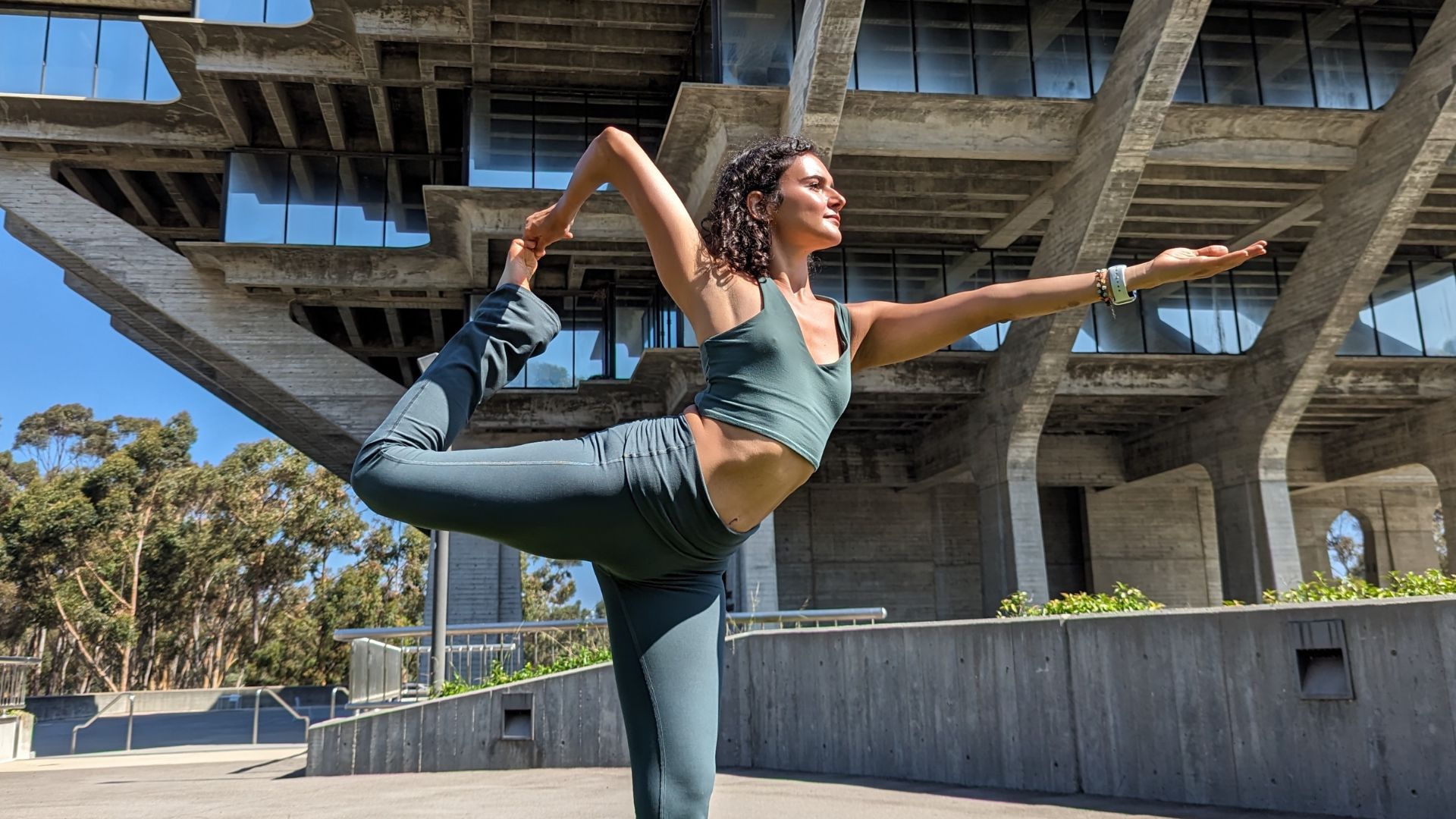 Yoga instructor posing in front of Geisel Library at UC San Diego.