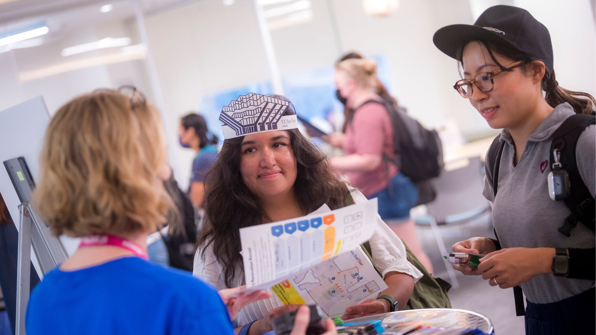 Photo of two students speaking with a librarian at a past event at Geisel Library.