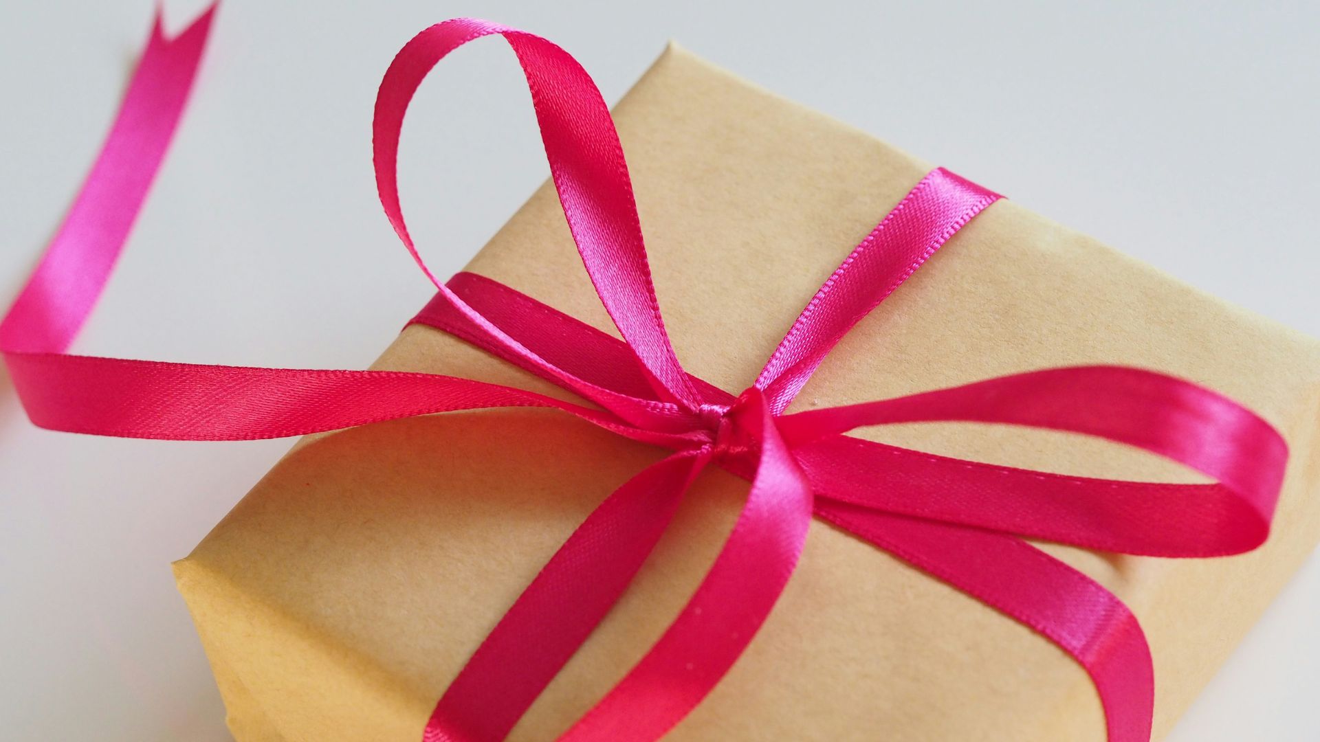 A photo of a gift box wrapped with a red ribbon