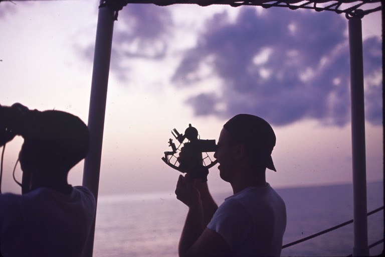 Using a sextant to determine latitude and longitude at sea, on the USC&GS Pioneer during the International Indian Ocean Expedition. 1964
