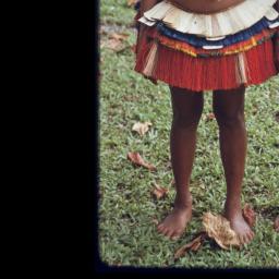 Adolescent girl wearing short fiber skirt stands with young girl in cloth  dress, both wear red shell necklaces, Library Digital Collections